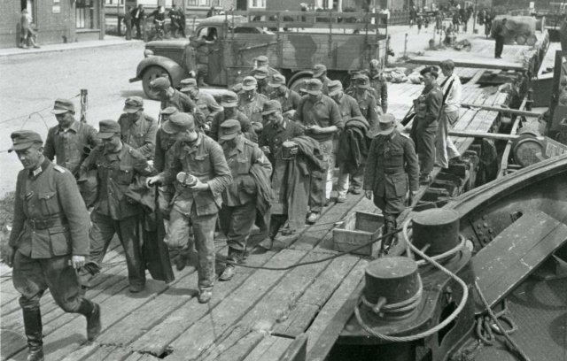 View of the employment of prisoners of war at the Eemskanaal N.Z. Unloading of, among other things, food supplies under the supervision of the Canadians.